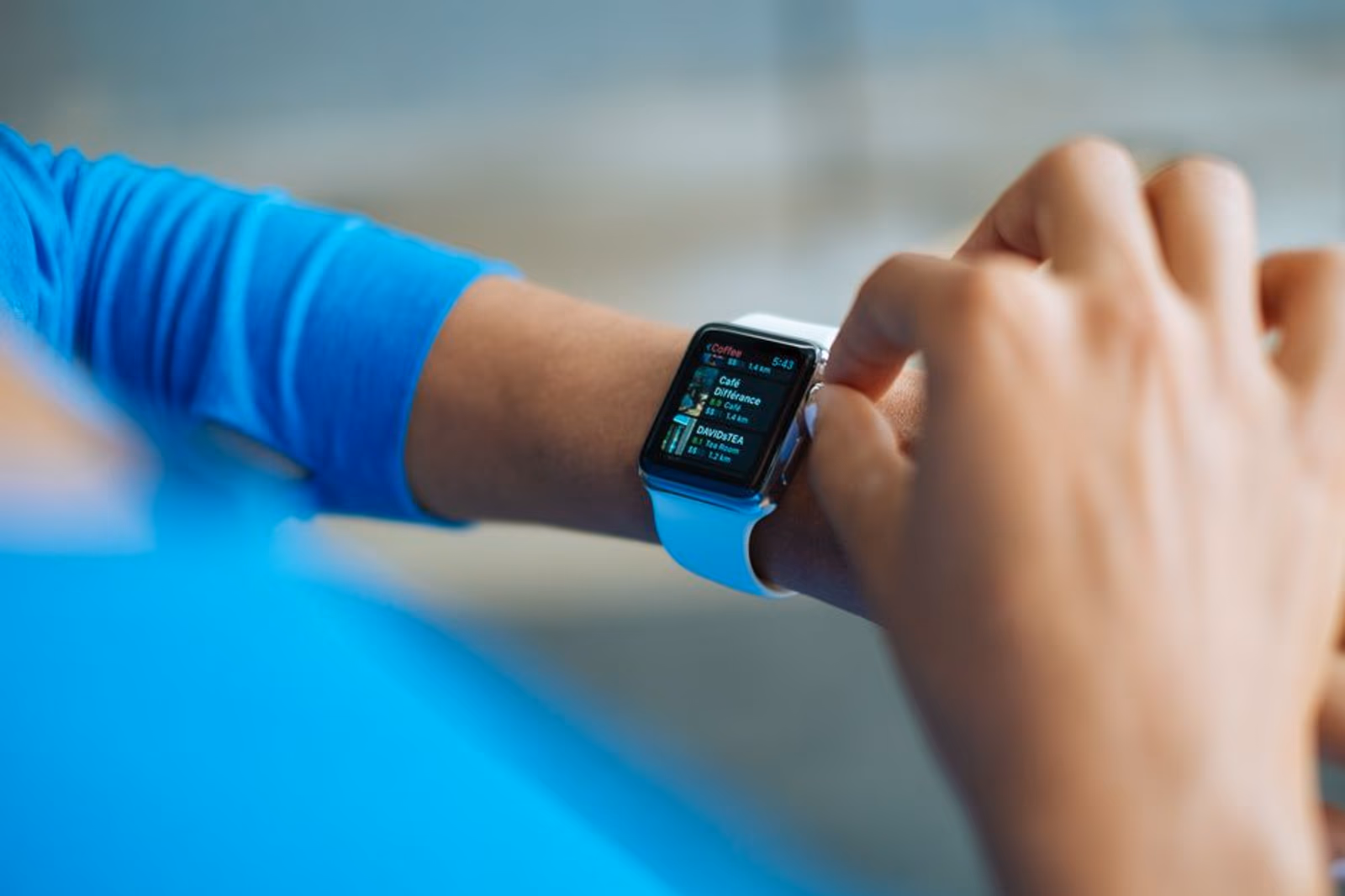 Smartwatch and mobile phone side by side showing app store search results for a cross-device fitness app
