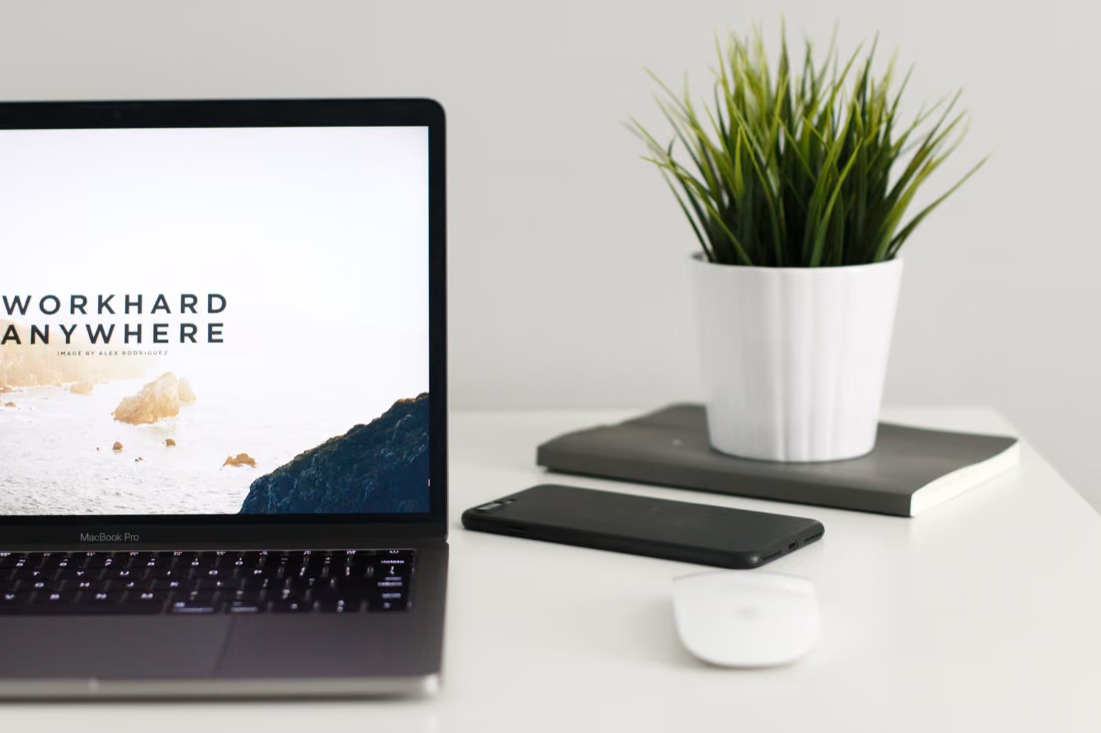 MacBook displaying "WORK HARD ANYWHERE" — the B2B SaaS mobile companion thesis.