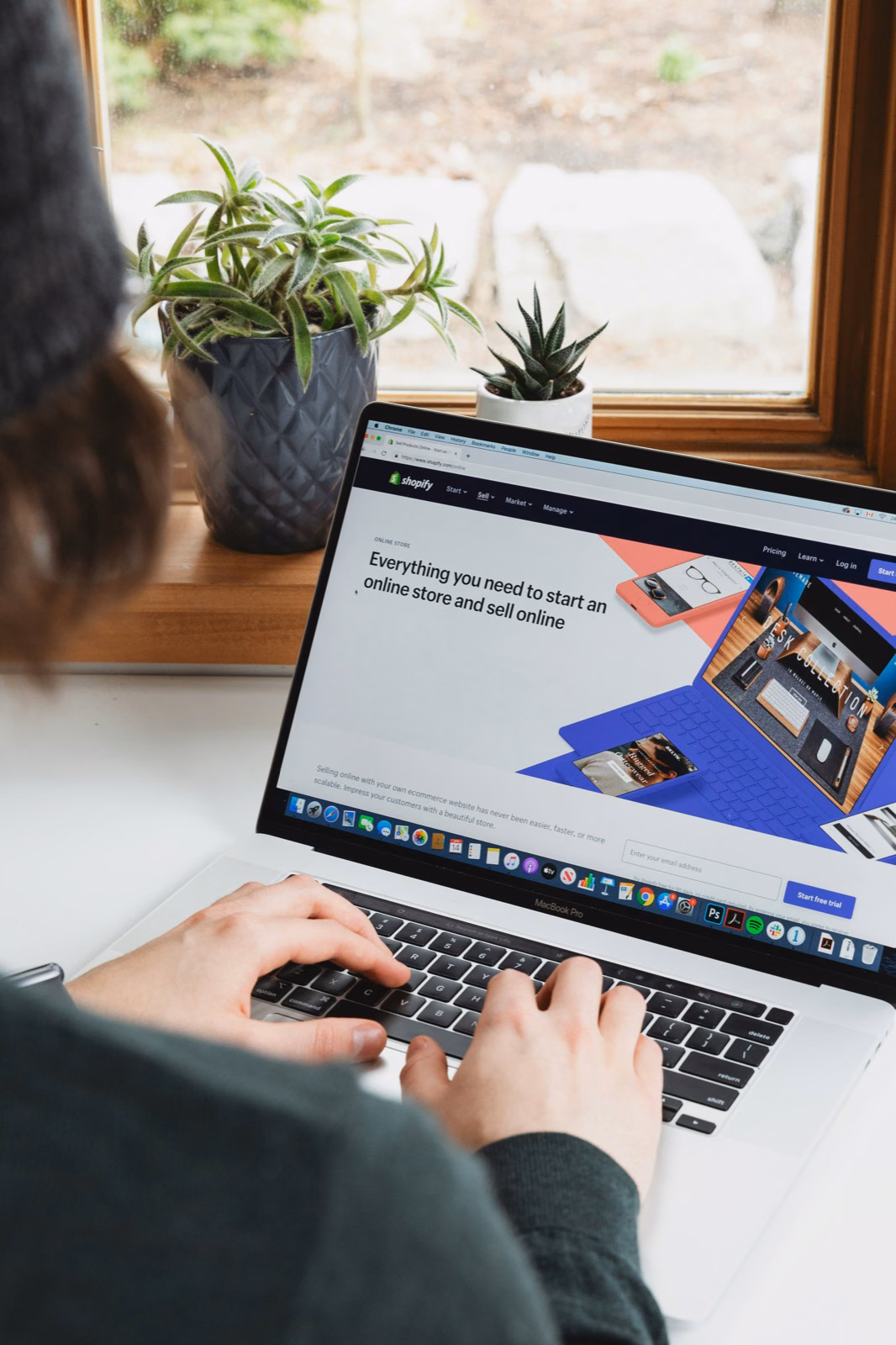 Person working on a laptop showing a marketplace platform landing page about starting an online store and selling online.