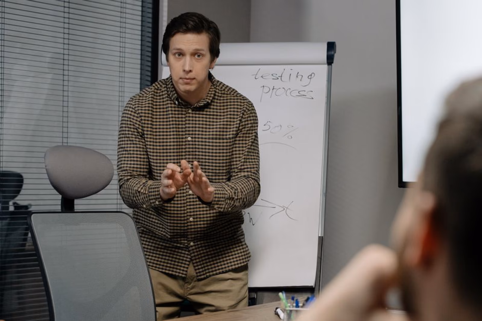 A creative testing team reviewing app ad concepts on a whiteboard and laptop screens