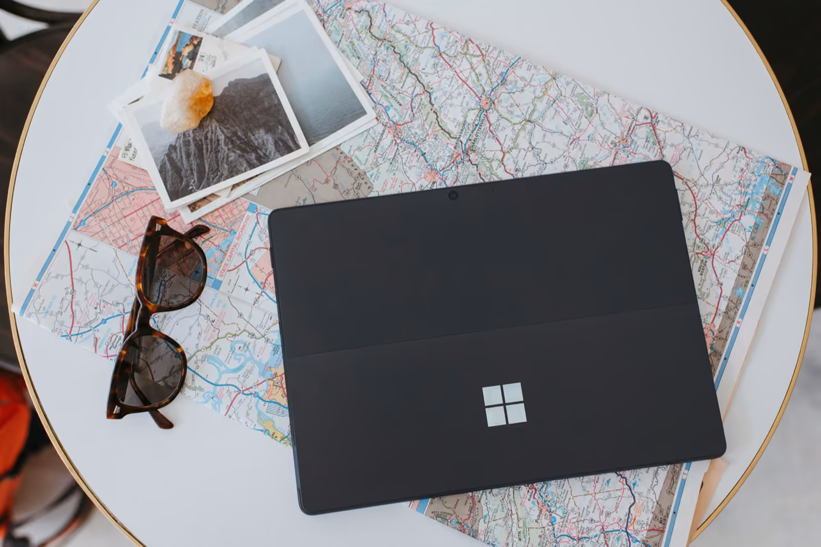 A Microsoft Surface and a paper map on a café table — planning the route before the build.