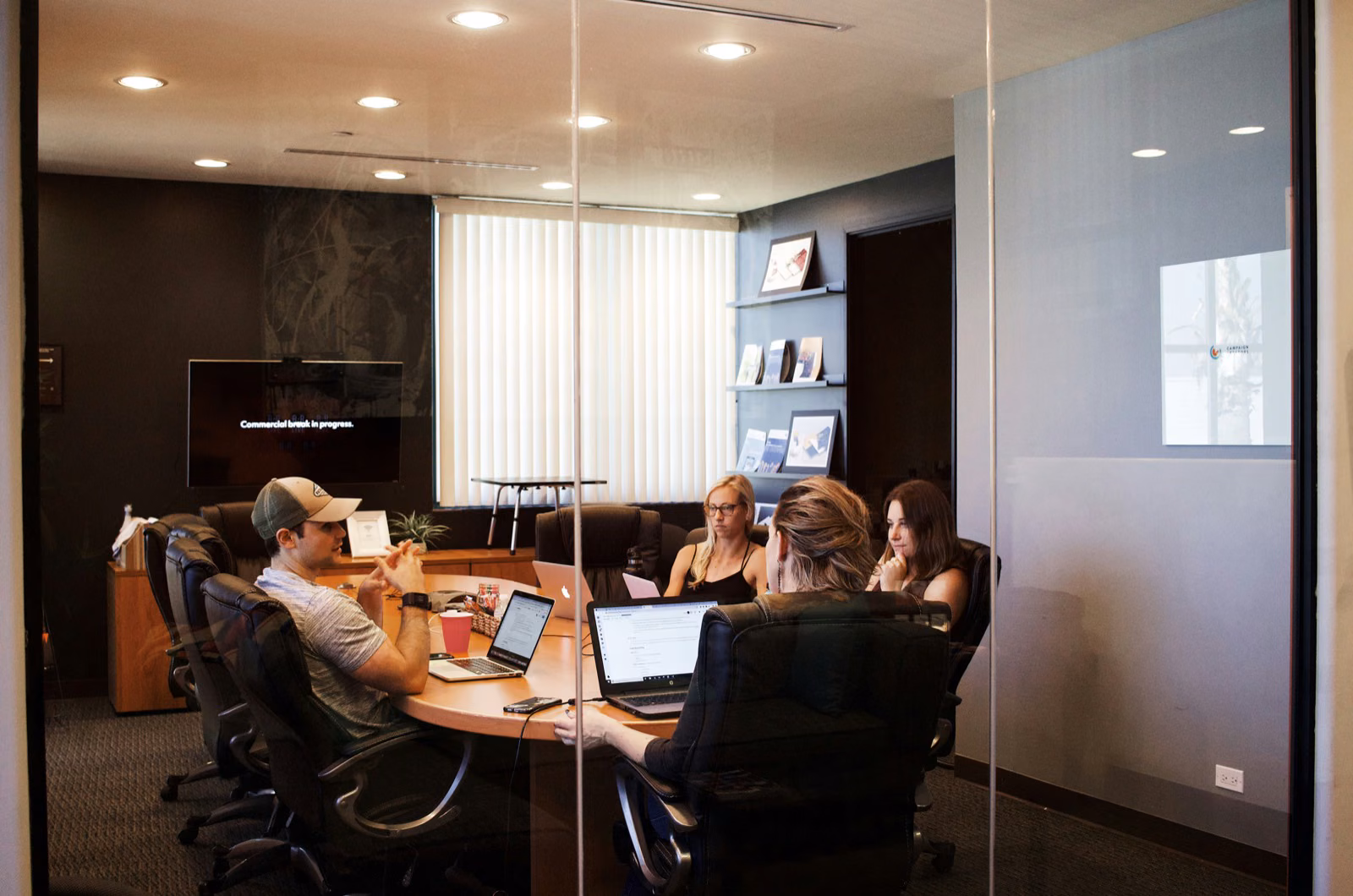 HR operations team reviewing employee data and automated workflow status across a modern office workspace.