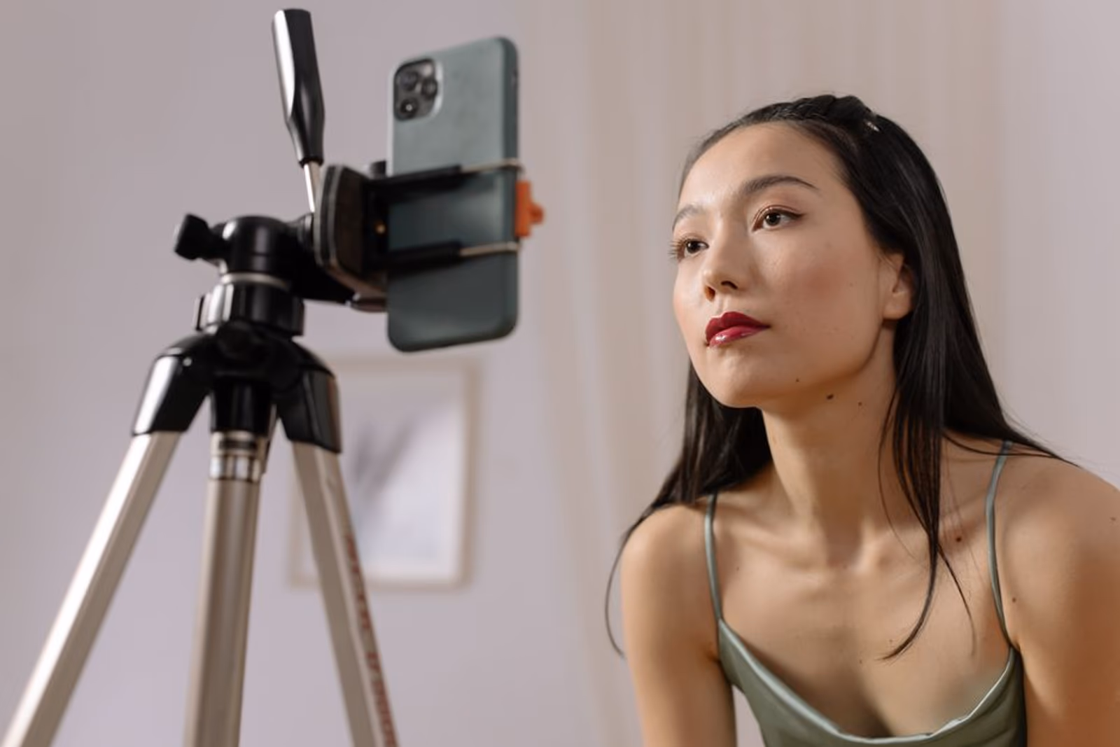 A content creator filming a product review video on a smartphone in a studio setting
