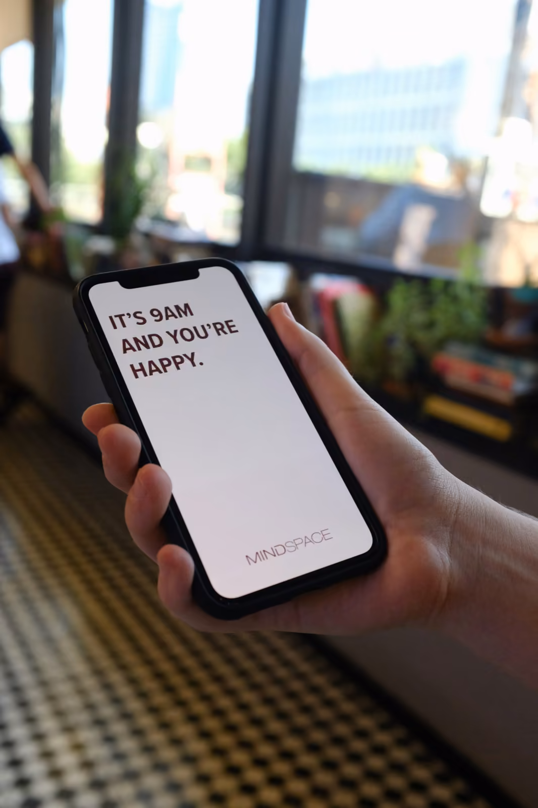 A phone screen with "It's 9AM and you're happy" — the visual of a healthy post-launch user.