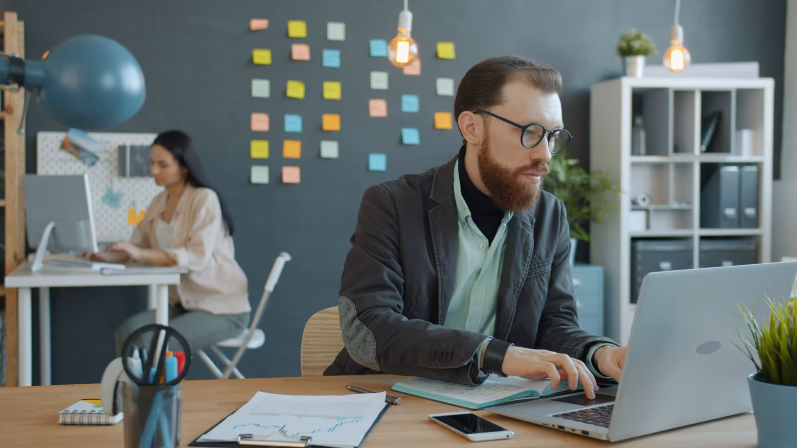 Senior engineer at a desk in a real office, hands on keyboard, focused.