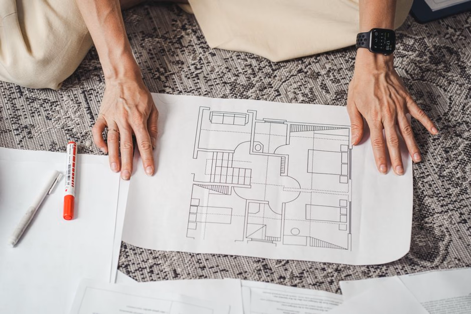 Construction blueprint spread on a table with revision marks and a pencil