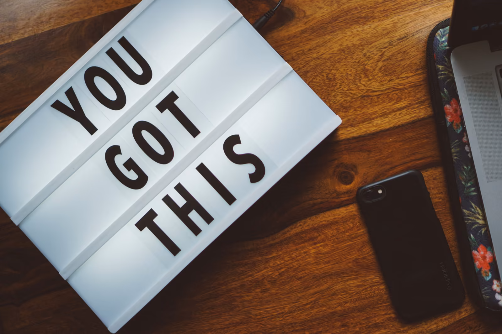 A "YOU GOT THIS" sign by a phone — the visual of momentum carried past launch.